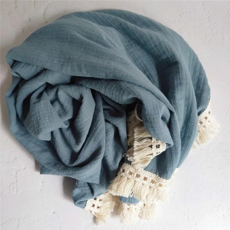 Plaid bébé enmousseline bleu avec franges en dentelle bohème, idéal pour envelopper votre enfant de douceur et apporter une touche élégante à sa chambre.