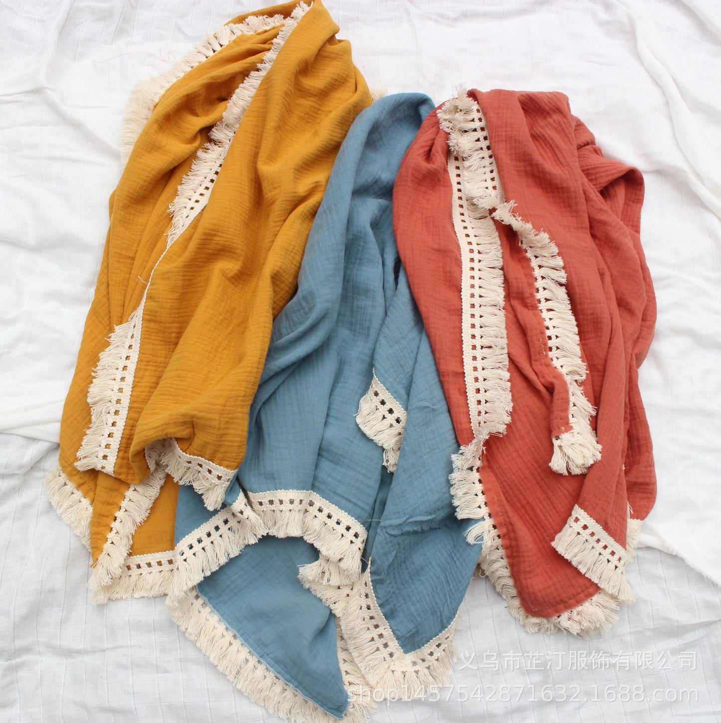 Plaid bébé en coton gaufré avec franges en dentelle, disponible en trois couleurs tendances – jaune, bleu et orange – idéal pour offrir douceur et chaleur tout en apportant une touche bohème et élégante à la chambre de bébé.