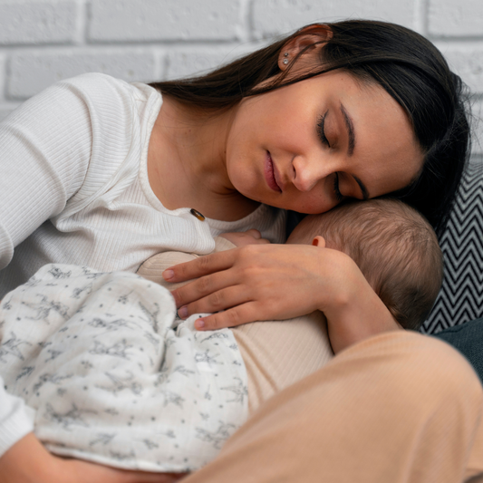 Une régression sommeil bébé provoque souvent un épuisement intense chez les parents, comme en témoigne cette maman endormie sur le canapé avec son nourrisson après des réveils nocturnes répétés.
