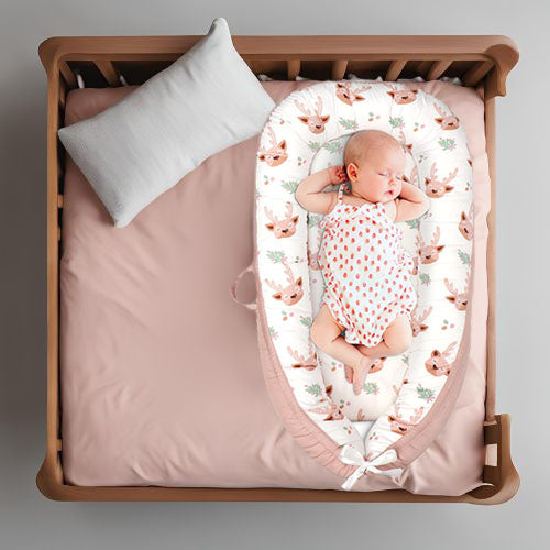 Dans un cocon bebe doux motif de cerfs, bébé confortablement installé sur un lit.