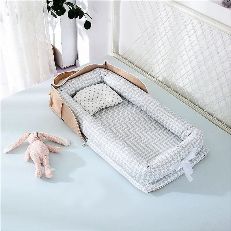 Cocon bebe beige avec motifs géométriques gris.