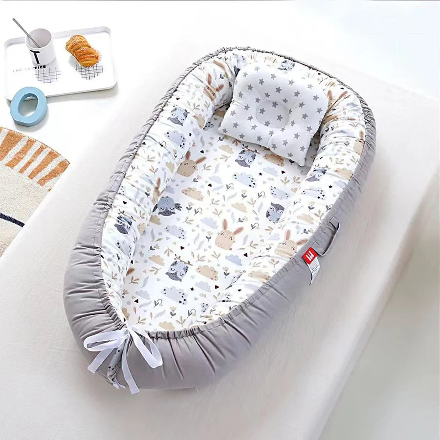 Cocon bebe gris avec motifs chouettes et oreiller assorti.