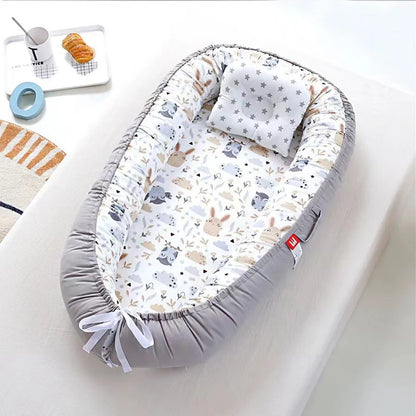 Cocon bebe gris avec motifs chouettes et oreiller assorti.