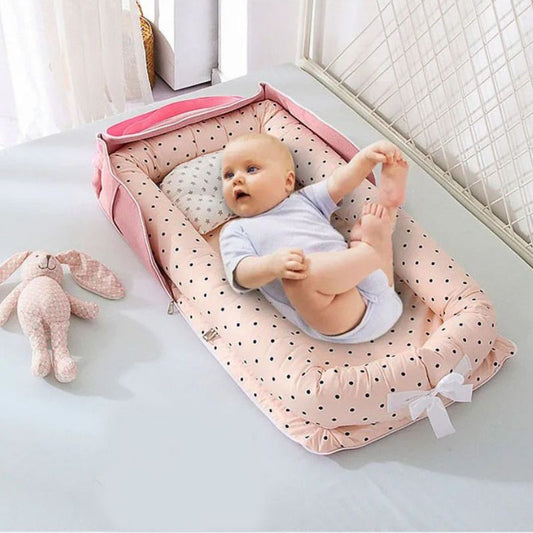 Cocon bebe rose , petits pois noirs, avec bébé confortable a l'intérieur.