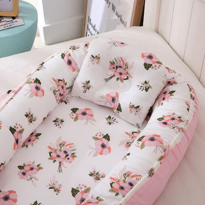 Couffin bébé avec motifs floraux roses, coussin assorti inclus.