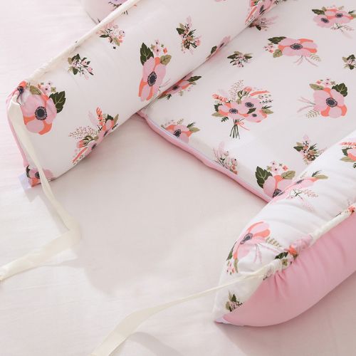 Couffin bébé floral rose avec liens ajustables et matelas doux.