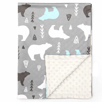 Couverture bébé douce et moelleuse avec un motif d'ours polaires blancs, noirs et bleus sur fond gris, décorée de flèches et formes géométriques, doublée d'un tissu en relief à pois blanc cassé, parfaite pour apporter chaleur, confort et style à la chambre de bébé.