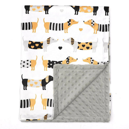 Couverture bébé douce et réversible avec un motif amusant de chiens saucisse en noir, jaune et blanc décorés de cœurs, et un verso en tissu minky gris à pois en relief, idéale pour apporter chaleur et confort aux tout-petits.