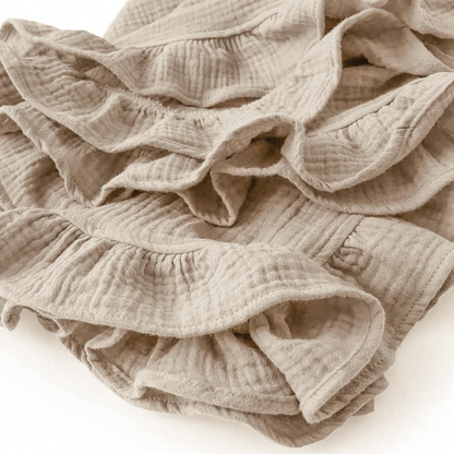 Couverture bébé en mousseline de coton beige avec de jolis volants, offrant une texture douce et respirante, idéale pour envelopper votre bébé avec confort et élégance.