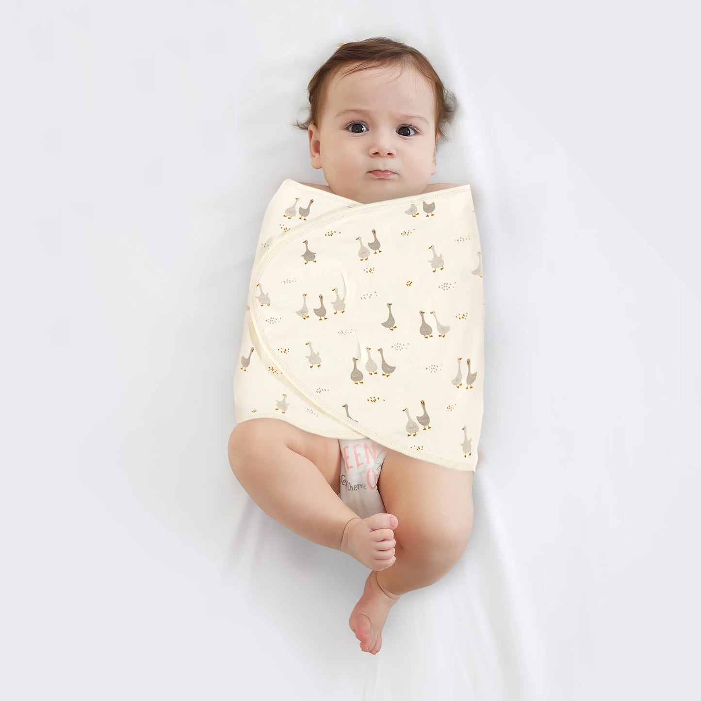 Couverture emmaillotage bébé motif canard enveloppant un nouveau-né pour un sommeil apaisé et sécurisé avec fermeture velcro pratique.