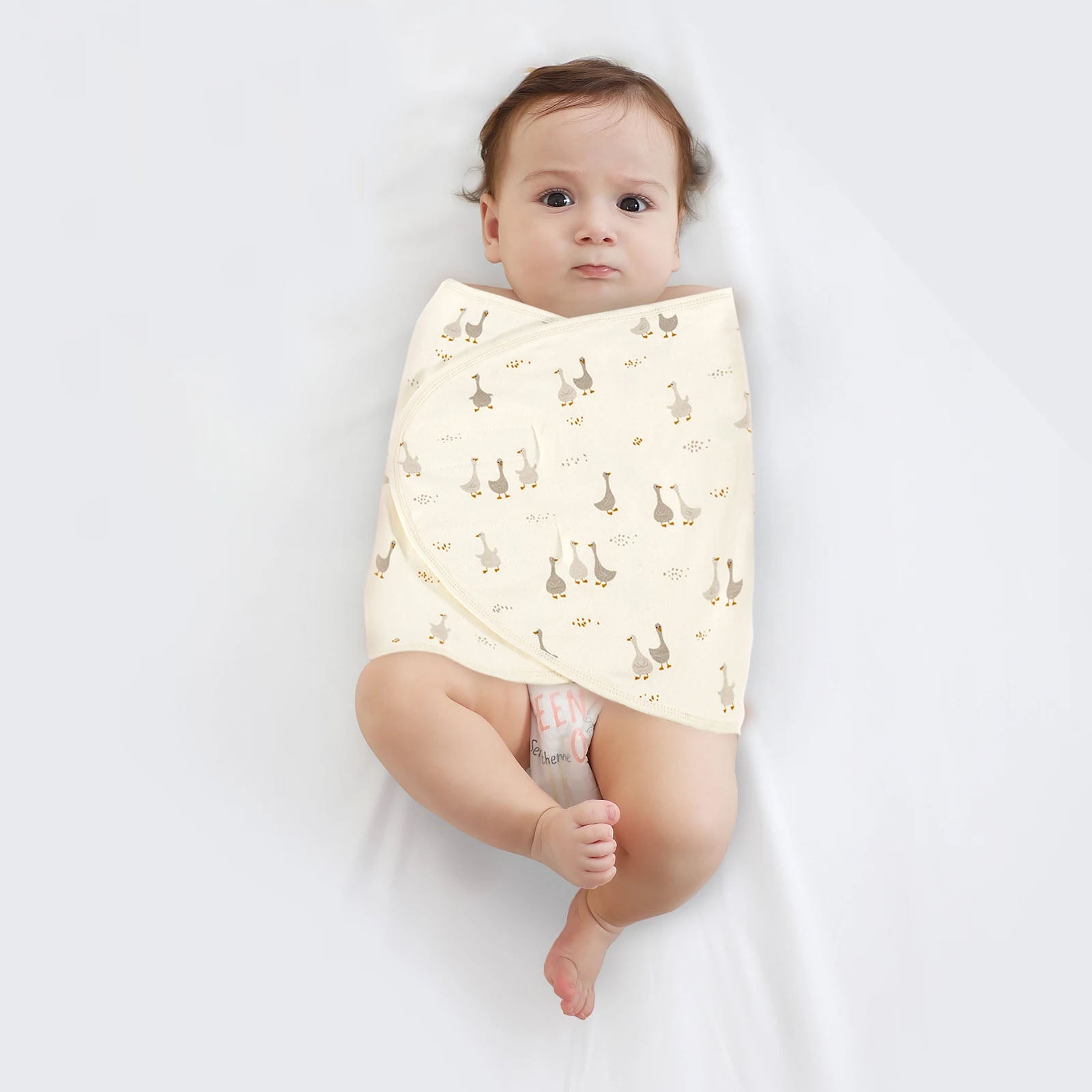 Couverture emmaillotage bébé motif canard enveloppant un nouveau-né pour un sommeil apaisé et sécurisé avec fermeture velcro pratique.