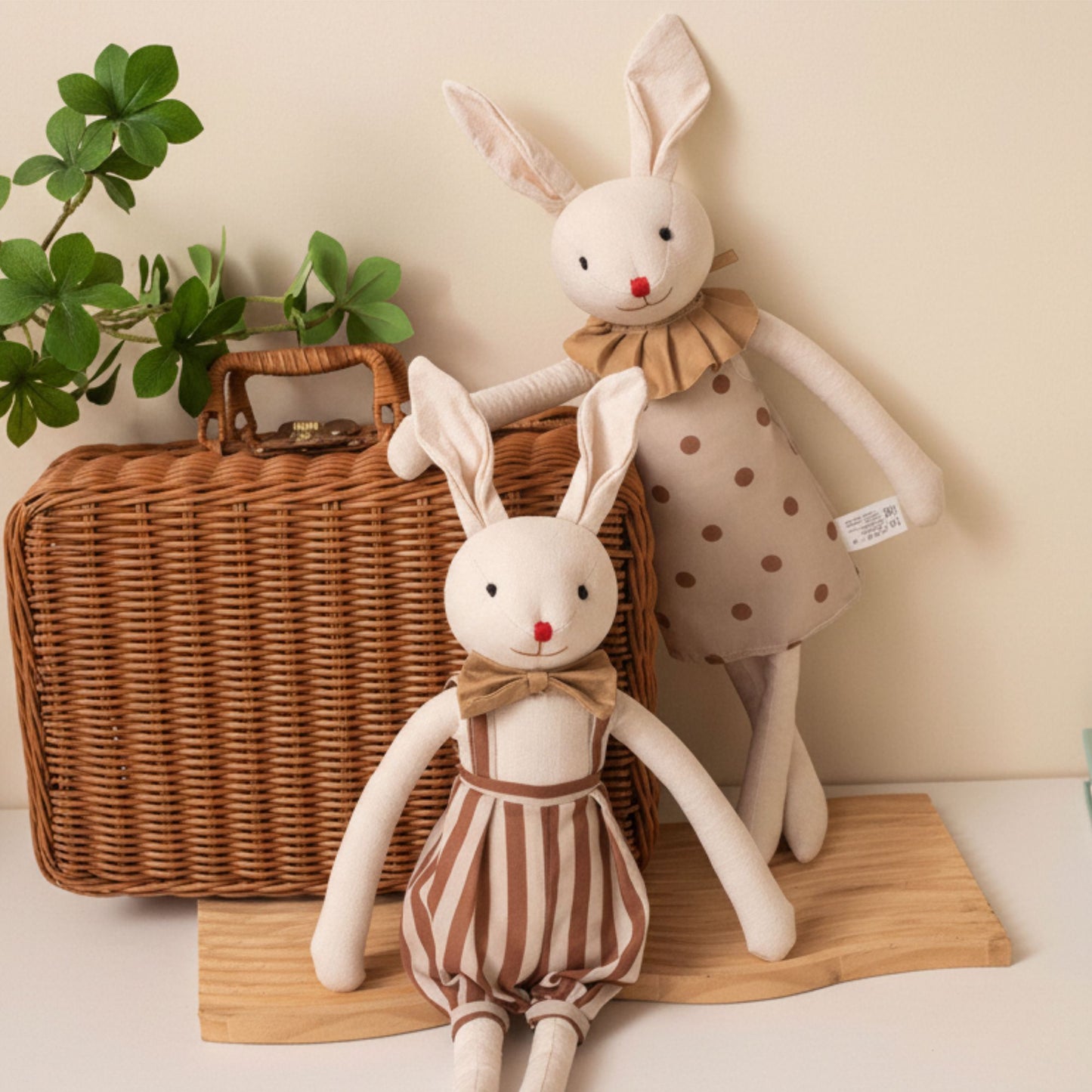 Peluche lapin Ribambelle™ duo fille et garçon devant valise en osier et plante verte — décoration chambre bébé cosy nordique