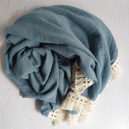 Plaid bébé enmousseline bleu avec franges en dentelle bohème, idéal pour envelopper votre enfant de douceur et apporter une touche élégante à sa chambre.