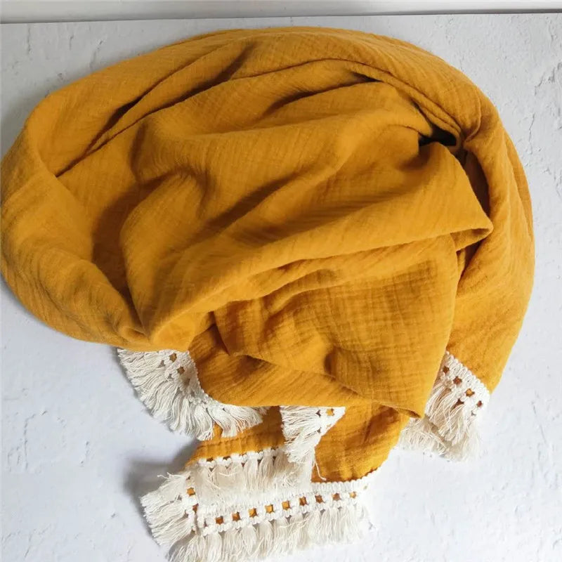 Plaid bébé en mousseline jaune avec franges en dentelle bohème, idéal pour envelopper votre enfant de douceur et apporter une touche élégante à sa chambre.