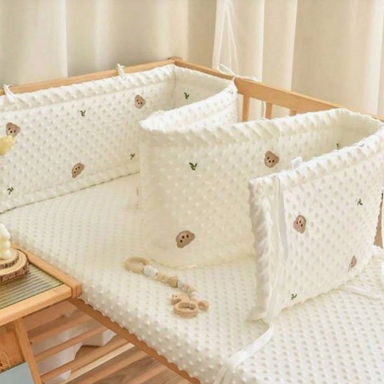Tour de lit bébé blanc matelassé avec motifs ourson, protection antichoc pour barreaux de berceau, literie bébé douce et confortable.