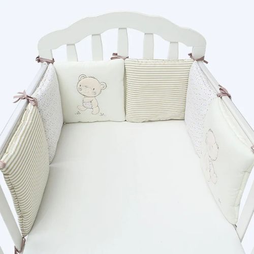 Tour de lit rembourré avec motifs oursons et rayures attaché au lit.