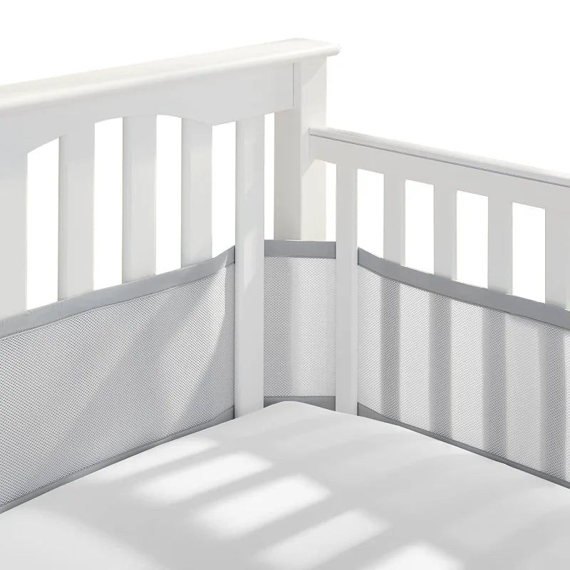 Tour de lit respirant de couleur gris neutre, installé dans un lit, offrant une protection douce et un design épuré, idéal pour créer un environnement sûr et confortable pour bébé.