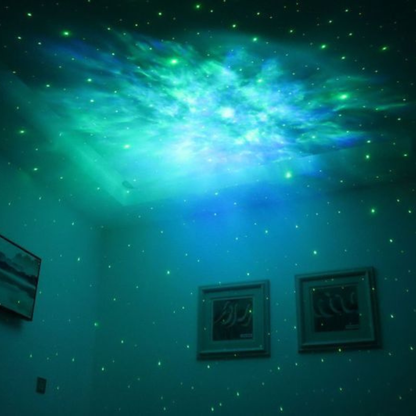 Astronaute projecteur projetant des étoiles vertes et une nébuleuse sur un mur.