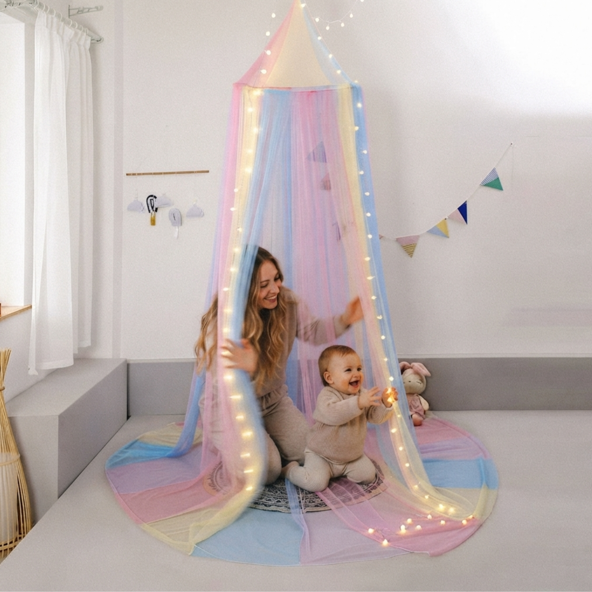 Ciel de lit enfant aux couleurs arc-en-ciel avec guirlande lumineuse, installant une ambiance féerique dans une chambre de bébé.