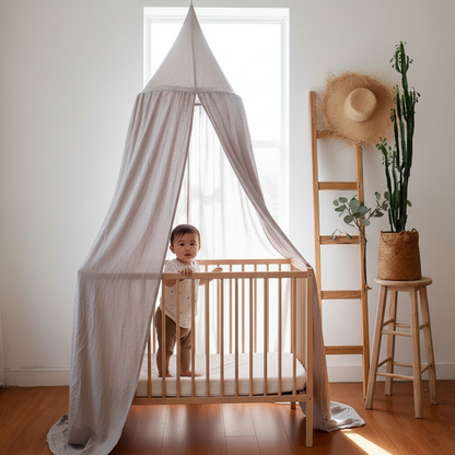Ciel de lit suspendu au-dessus d'un lit de bébé à barreaux en bois dans une pièce lumineuse.
