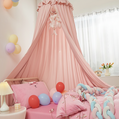 Ciel de lit bébé rose bonbon dans une chambre de petite fille, avec des meubles blancs et des décorations pastel.