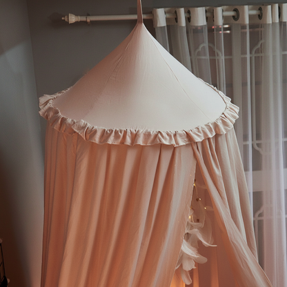 Ciel de lit bébé rose gros plan sur le tissu léger et aérien rose poudré en voile.