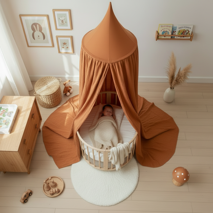 Ciel de lit terracotta surplombant un berceau rond posé sur un tapis blanc dans une chambre lumineuse.
