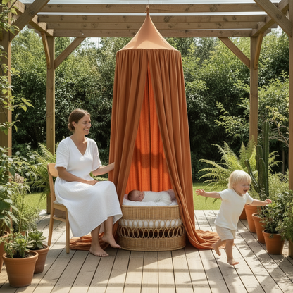 Ciel de lit extérieur installé sur une terrasse en bois pour créer un espace de jeux ombragé et douillet pour bébé.