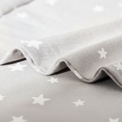 Gigoteuse avec jambes, vue rapprochée du motif étoiles et de la texture du tissu.