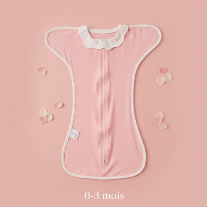 Gigoteuse bébé rose, modèle 0-3 mois avec col Claudine, présentée sur un fond doux avec des pétales.
