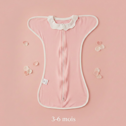 Gigoteuse bébé rose, modèle 3-6 mois avec col Claudine, présentée sur un fond doux avec des pétales.
