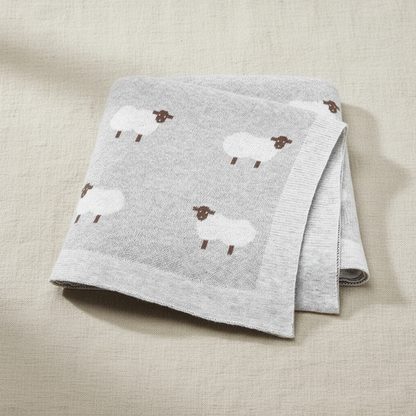 Lange bébé gris perle avec moutons blancs, présenté plié, idéal pour un cadeau de naissance mixte.
