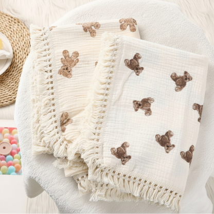 lange bébé lot de deux langes en mousseline de coton crème pliés avec bordures à franges.