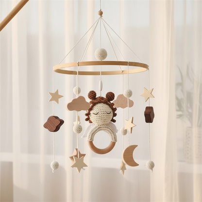 Mobile pour lit bébé style boho suspendu dans une chambre avec lumière naturelle douce, cerceau en bambou et décorations célestes