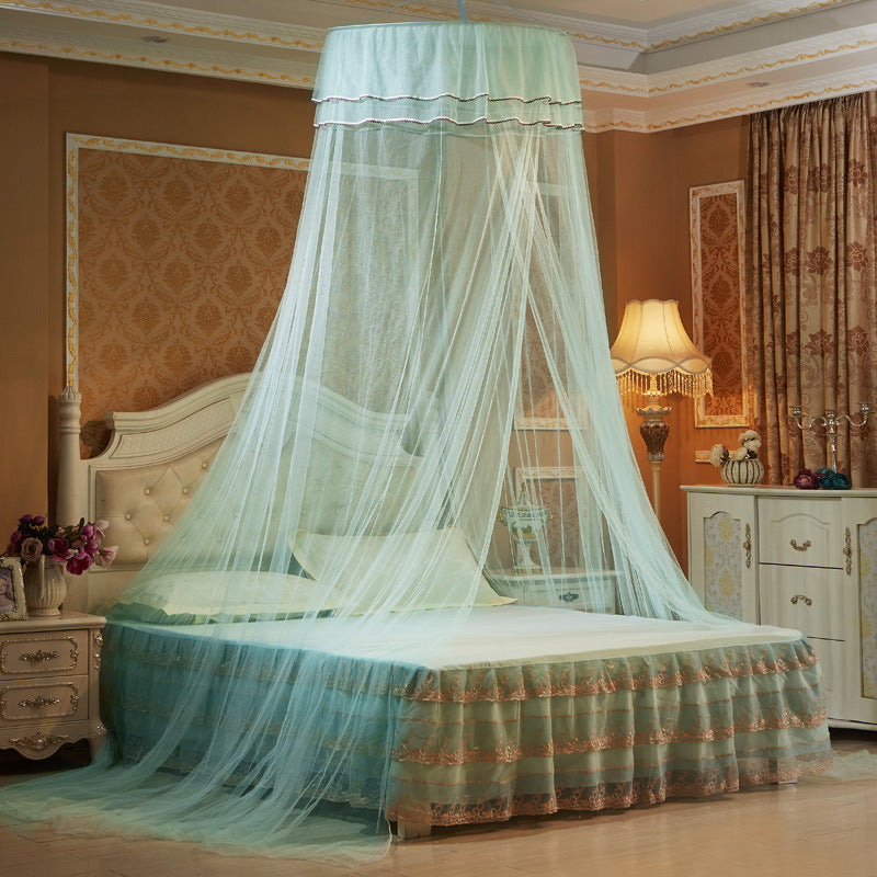 Moustiquaire lit bébé turquoise disposée au-dessus d'un grand lit.