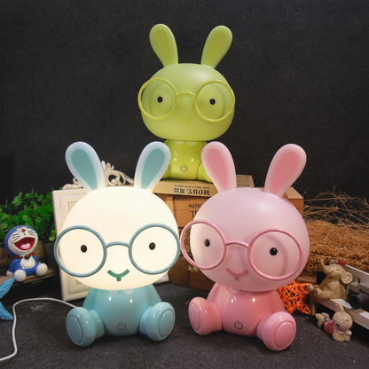 Veilleuse lapin déclinée en trois couleurs (bleu, rose et vert) présentée sur un fond sombre pour une chambre d'enfant.